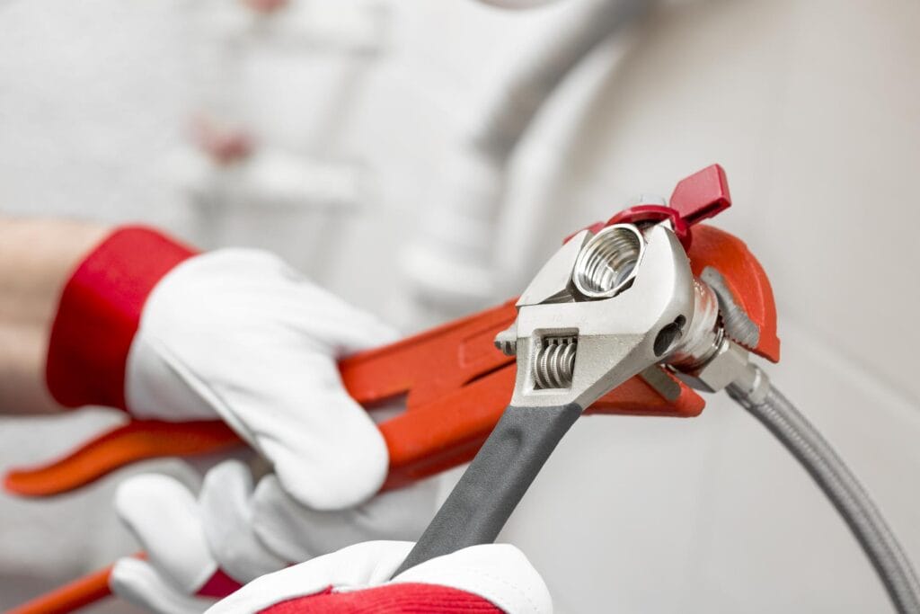 Plumber tightening pipe fitting for residential plumbing repair in Prescott Valley, Arizona