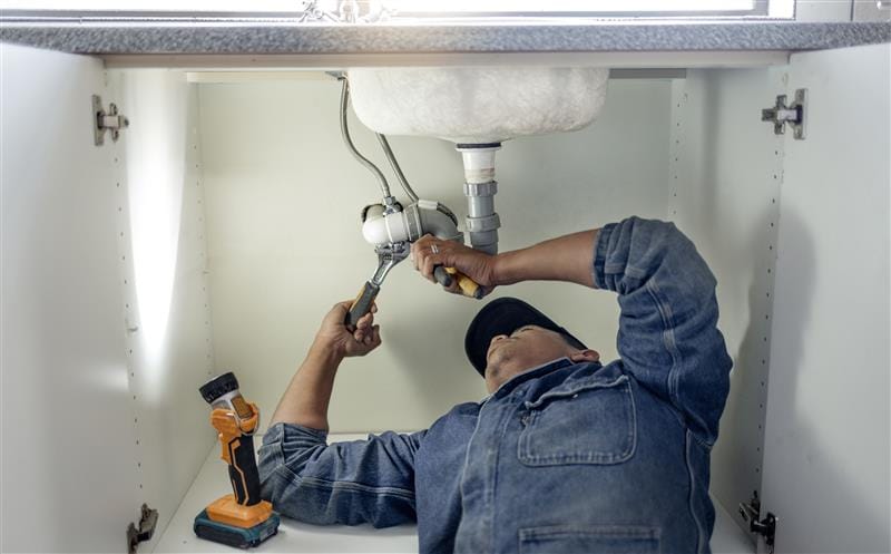 Plumber repairing kitchen sink drain pipes in Prescott Valley, Arizona